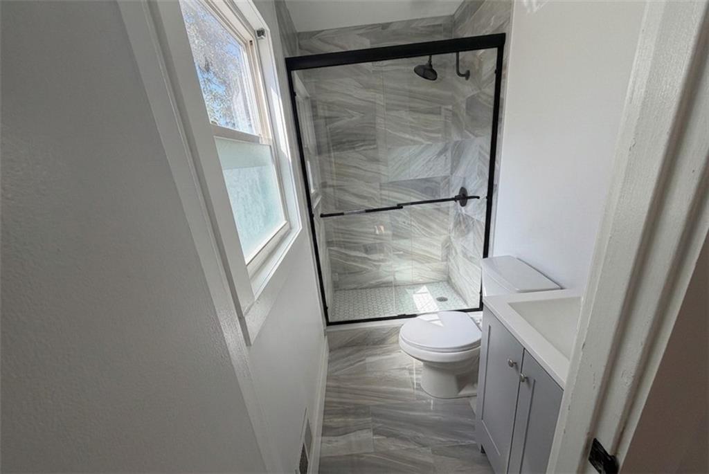 3763 Elkridge Drive Decatur, GA 30032 - Photo 13 of 20 a bathroom with a granite countertop toilet and a shower