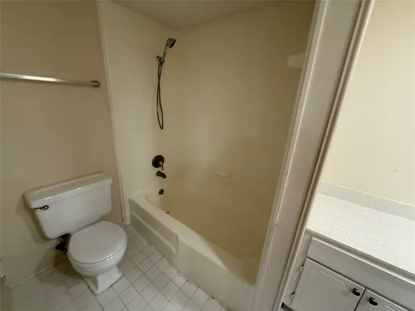 a white toilet sitting next to a bath tub