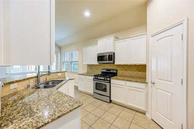 a kitchen with a stove a sink and a refrigerator