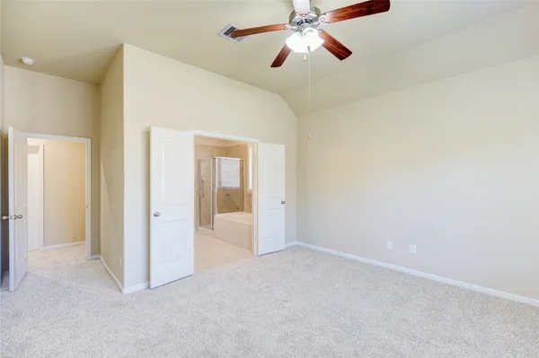 en empty room with closet and a chandelier fan