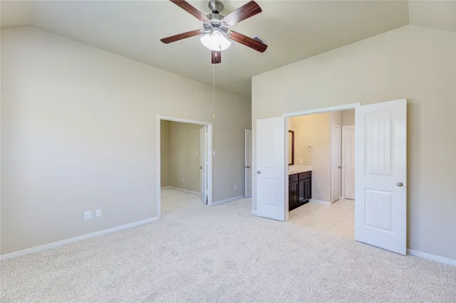 an empty room with closet and a chandelier fan