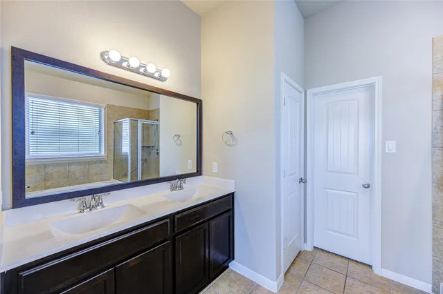 a bathroom with a double vanity sink and a mirror