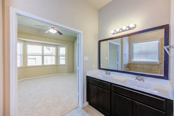 a en suite bathroom with a double vanity sink and a large mirror