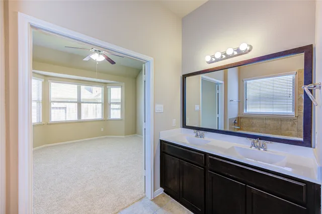 a en suite bathroom with a double vanity sink and a large mirror