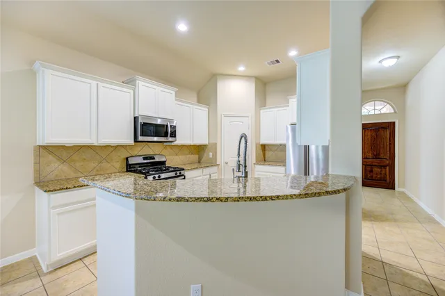 a kitchen with stainless steel appliances granite countertop a sink and a stove