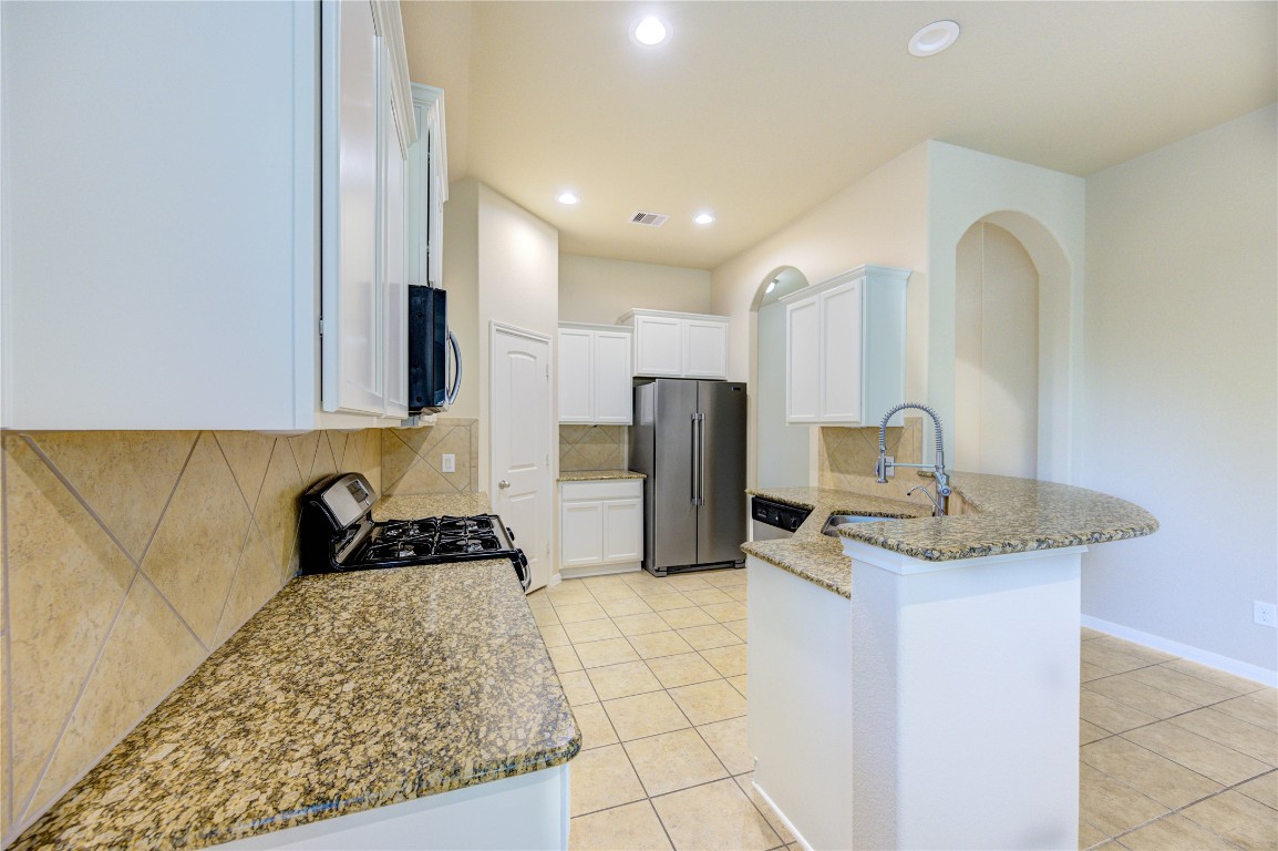 19306 Boulder Bay Lane Humble, TX 77346 - Photo 10 of 46 a kitchen with stainless steel appliances granite countertop a sink stove and refrigerator