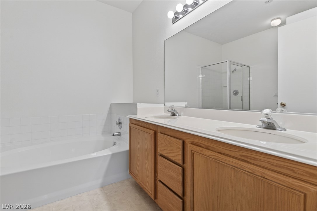 2201 Ramsgate Drive, Unit 1011 Henderson, NV 89074 - Photo 21 of 40 Double vanity and a deep tub offer a comfortable and functional bathing experience.