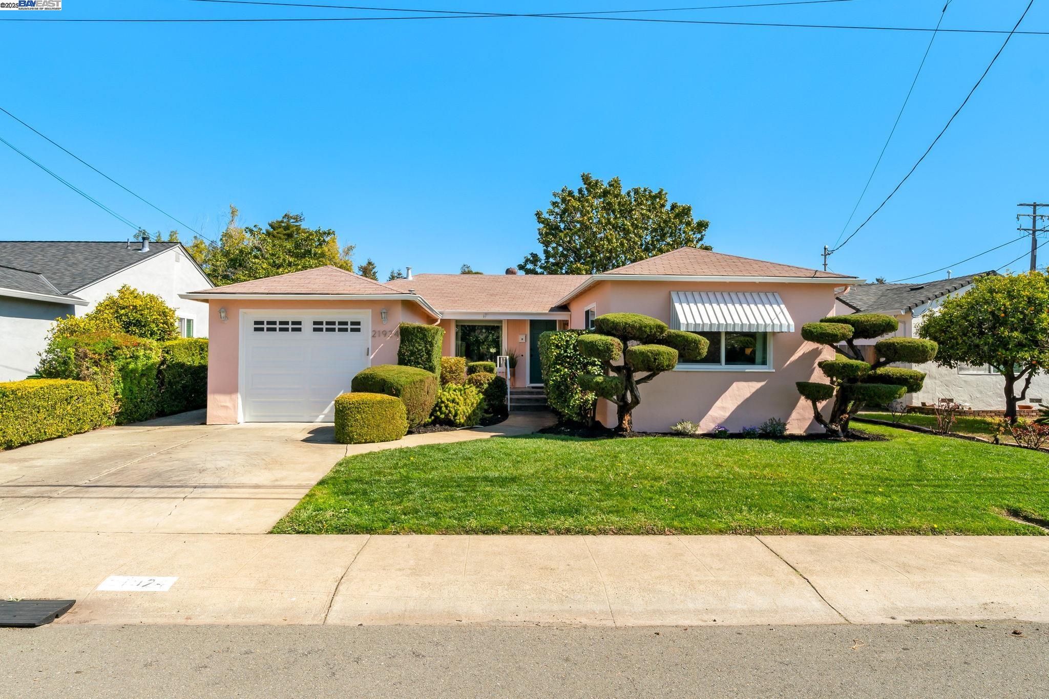 a view of a house with a garden and sitting area