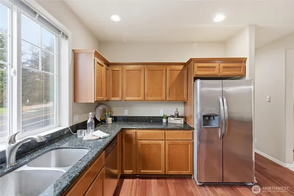 a kitchen with a refrigerator sink and cabinets