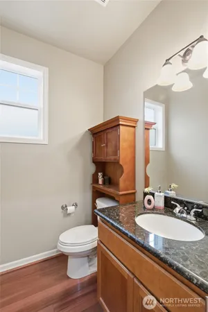 a bathroom with a granite countertop toilet a sink and a mirror