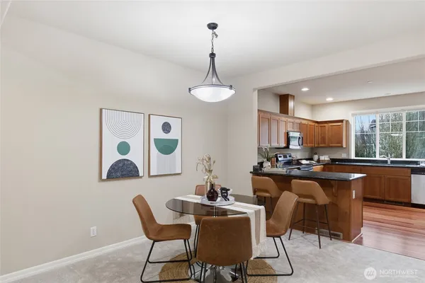 a dining room with wooden floor a chandelier a glass table and chairs