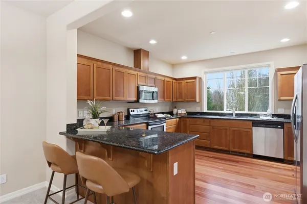 a kitchen with stainless steel appliances granite countertop a sink stove and microwave