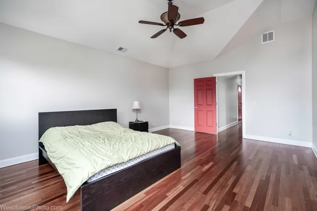 a bedroom with a bed and wooden floor