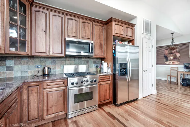 a kitchen with granite countertop a refrigerator stove and sink