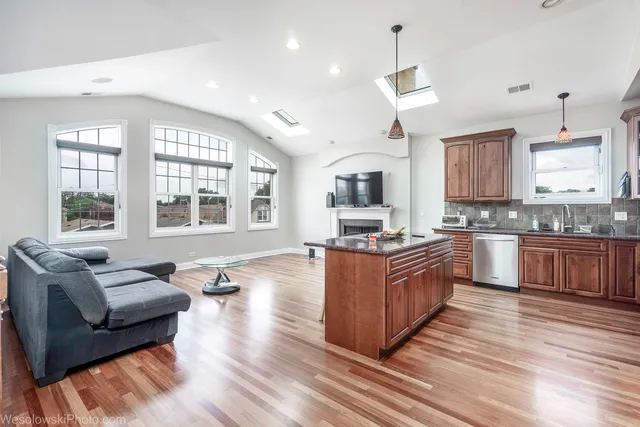 a kitchen with granite countertop wooden floors and white cabinets