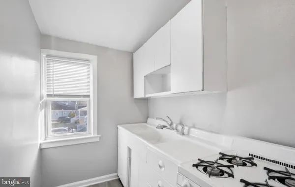 a white kitchen with sink and window