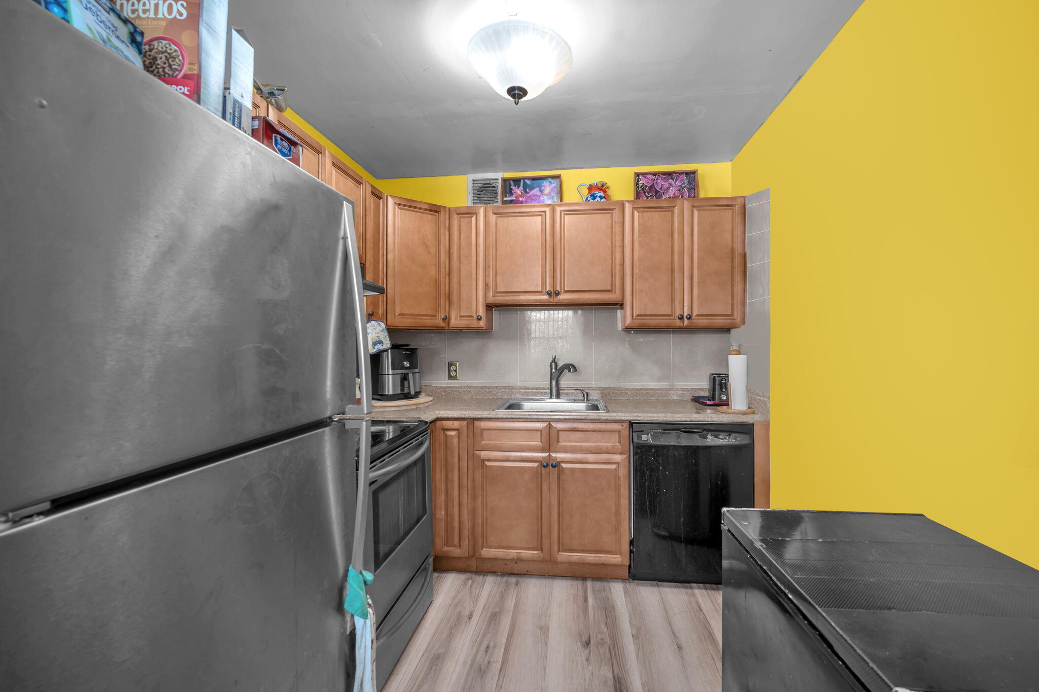 801 Southwest 133rd Terrace, Unit 317K Pembroke Pines, FL 33027 - Photo 5 of 13 a kitchen with a white cabinets sink and stainless steel appliances