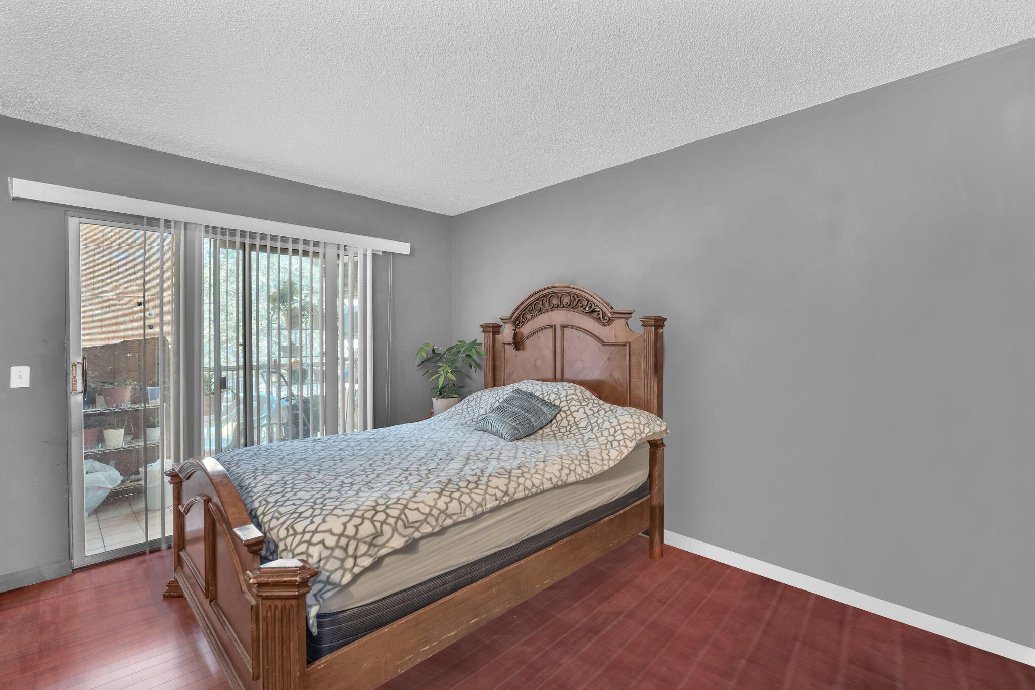 801 Southwest 133rd Terrace, Unit 317K Pembroke Pines, FL 33027 - Photo 6 of 13 a bedroom with a bed and wooden floor