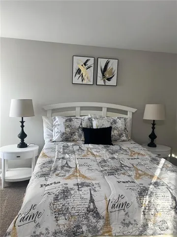 a bedroom with a bed and a lamp on table