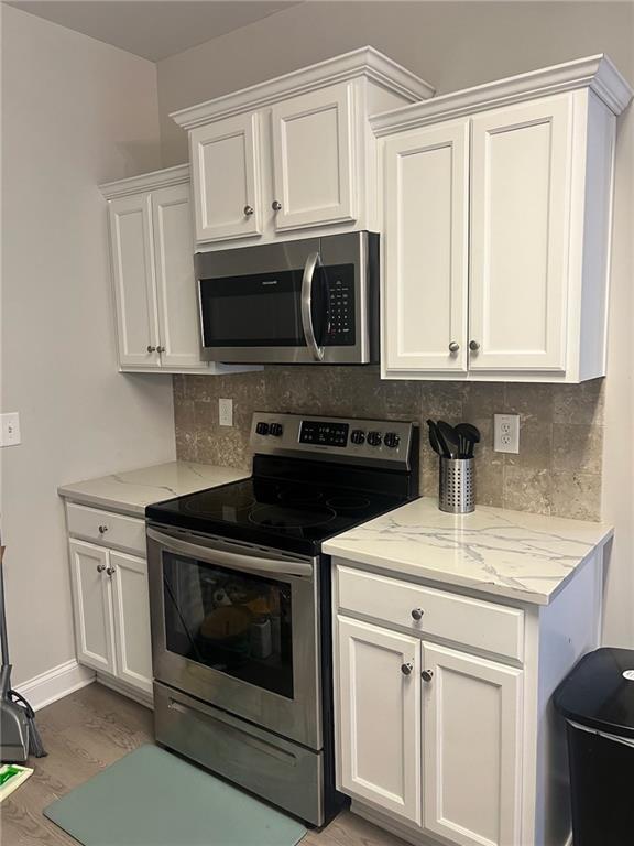 7150 Fringe Flower Drive, Unit 20 Austell, GA 30168 - Photo 37 of 41 a kitchen with granite countertop white cabinets and black appliances