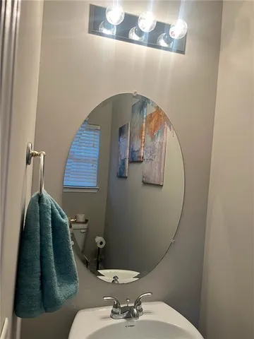 a bathroom with a toilet sink and mirror