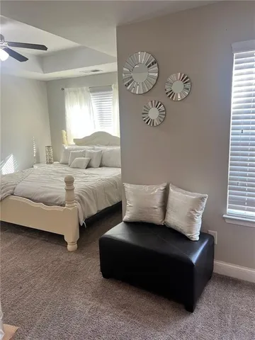 a bedroom with bed couch and window