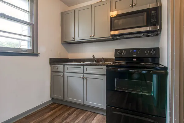 a kitchen with granite countertop a stove and a microwave