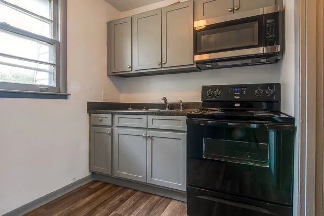 a kitchen with granite countertop a stove and a microwave