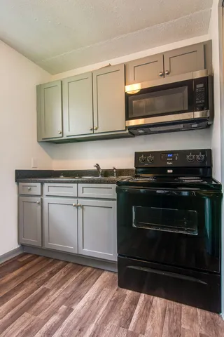 a kitchen with stainless steel appliances granite countertop a stove a sink and a microwave