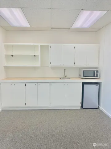 a kitchen with white cabinets and sink