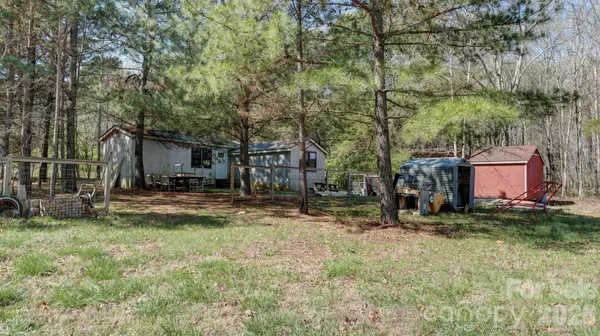 a view of a house with backyard and trees