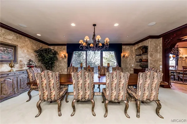 a view of a dining room with furniture and chandelier