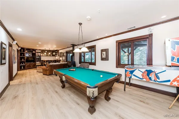 a room with furniture pool table and window
