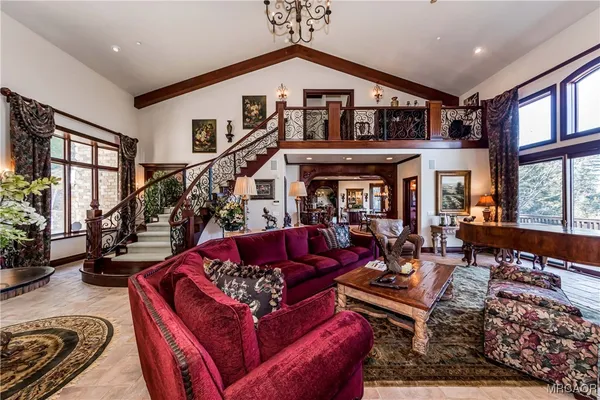 a living room with furniture fireplace and a large window