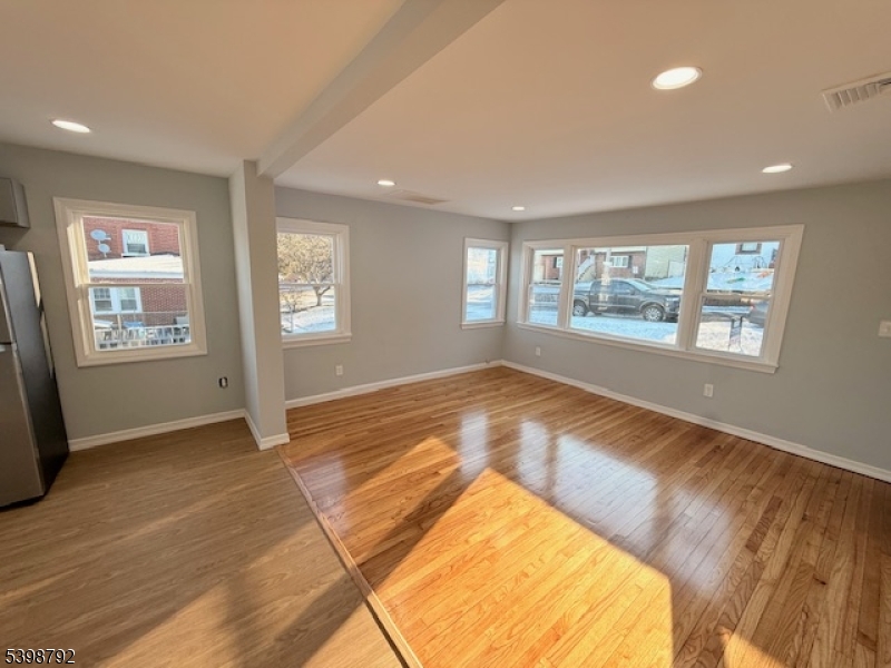 83 Academy Street Dover, NJ 07801 - Photo 4 of 14 a view of empty room with window and wooden floor