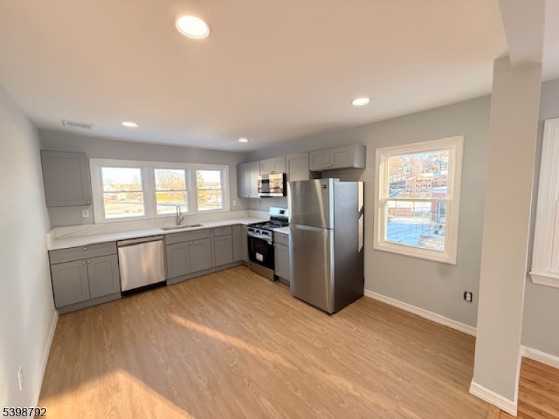 83 Academy Street Dover, NJ 07801 - Photo 5 of 14 a kitchen with refrigerator and windows