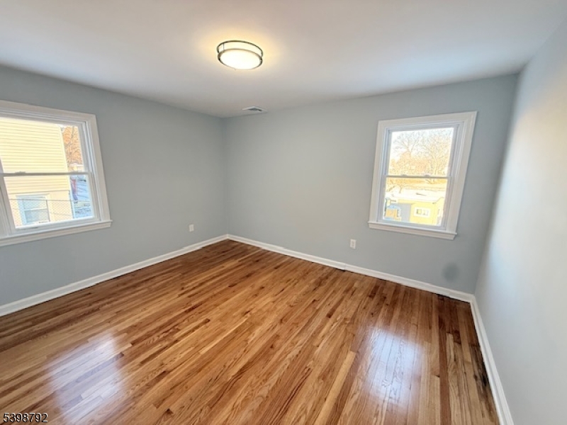 83 Academy Street Dover, NJ 07801 - Photo 8 of 14 an empty room with wooden floor and windows