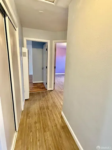 a view of a hallway with wooden floor and staircase