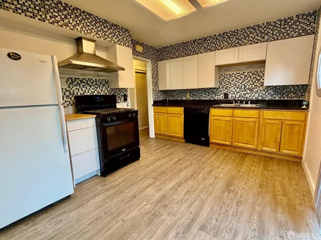 a kitchen with granite countertop a stove a sink and a refrigerator