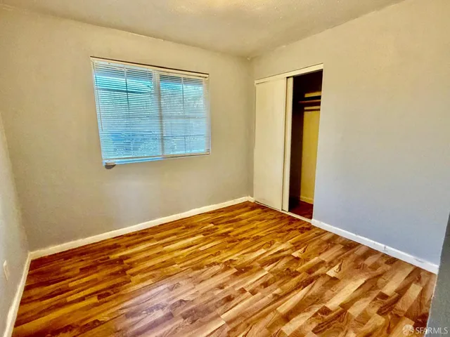 a view of a room with wooden floor and a window