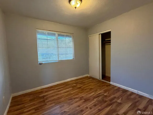 a view of a room with wooden floor and window