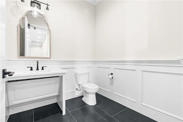 a bathroom with a sink a toilet and a mirror