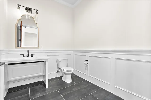 a bathroom with a toilet sink and mirror
