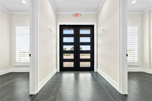 a view of hallway with window and wooden floor