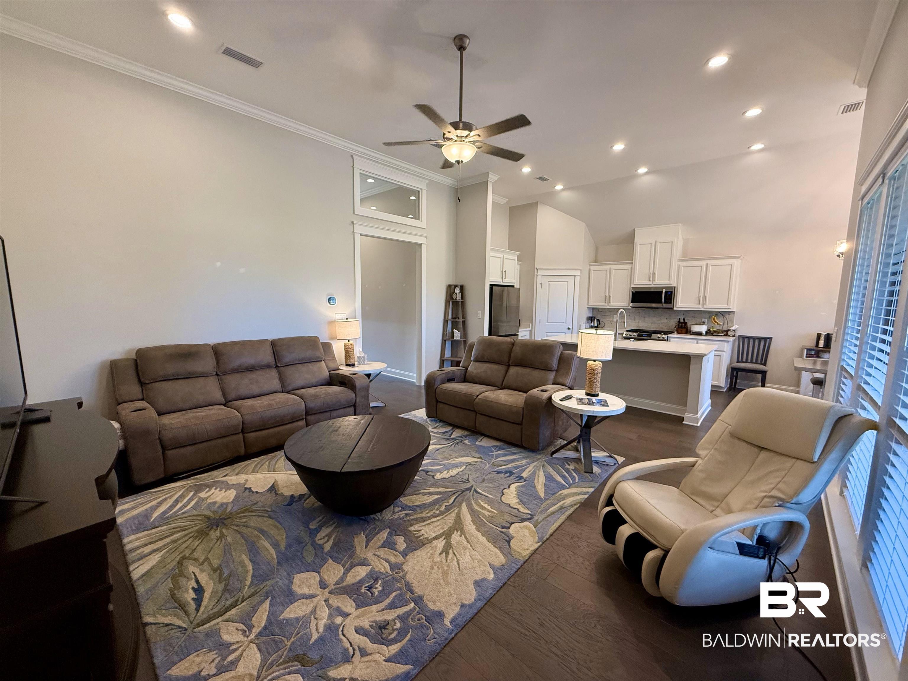31748 Canopy Loop Spanish Fort, AL 36527 - Photo 7 of 22 Living room featuring ceiling fan, ornamental molding, a towering ceiling, and dark hardwood / wood-style flooring