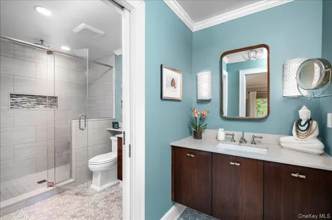 a bathroom with a double vanity sink toilet mirror and shower