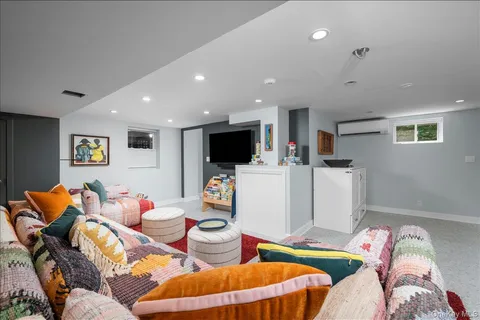 a living room with furniture and white kitchen appliances