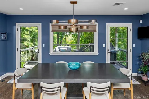 a view of a dining room with furniture a chandelier and wooden floor