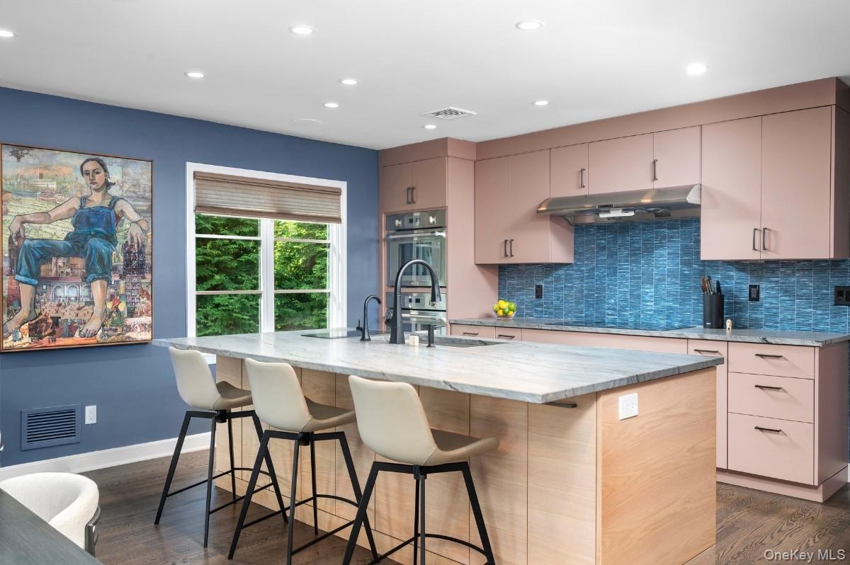 18 South Ridge Road Larchmont, NY 10538 - Photo 10 of 35 a kitchen with stainless steel appliances granite countertop a stove a sink a microwave a refrigerator and white cabinets with wooden floor