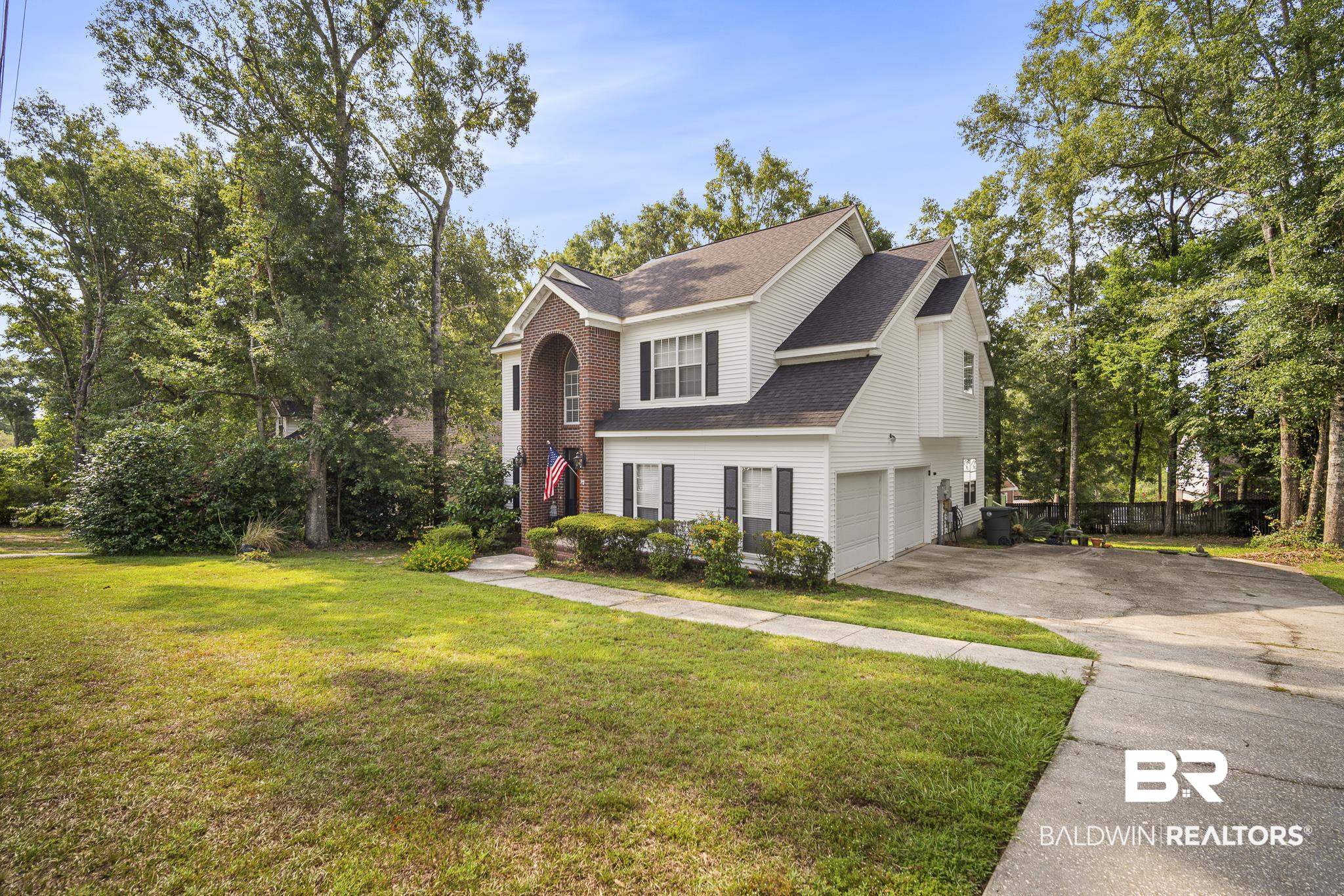 Two-story residence featuring white siding and brick accents, a gabled roofline, and dark window shutters